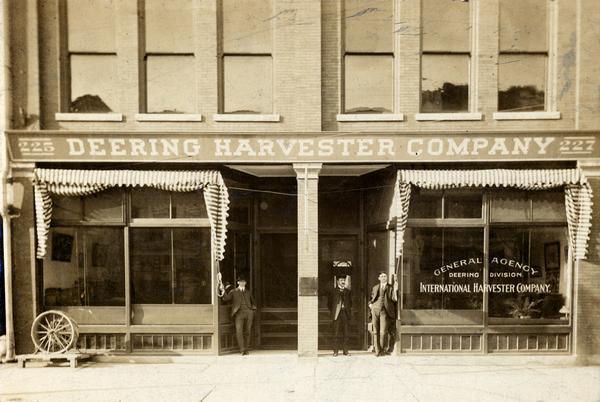 General agency building for the Deering Harvester Company in Fort Wayne, Indiana. J. W. Wischart, B. A. Horton, and G. E. Blieson are standing outside the building. Before 1902, the building served as an agency for the Deering Harvester Company. After 1902, it became an agency for the Deering Division of the International Harvester Company.