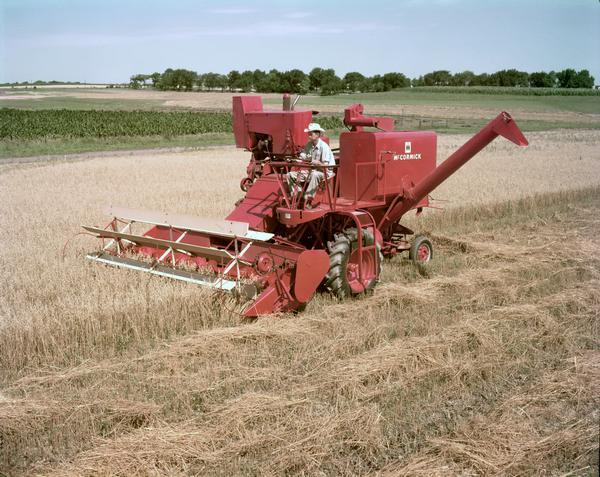 Man harvesting oats with a McCormick 127-SP harvester-thresher (combine).