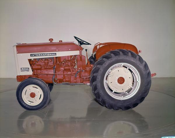 Color photograph of an International 504 tractor in a photo studio.