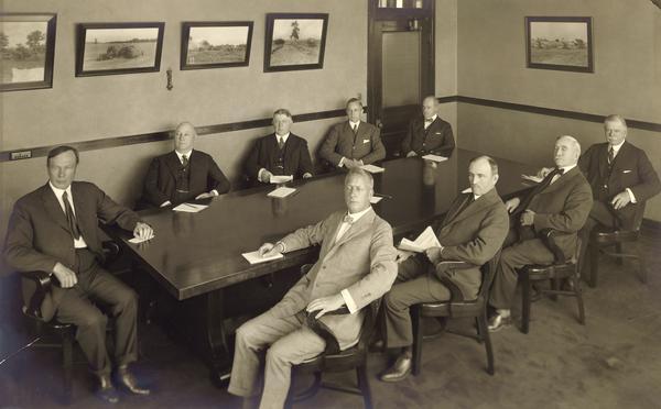 International Harvester Company president Alexander Legge sitting at the head of a board room table (at far left) with other company executives or board members. Cyrus McCormick, Jr. is sitting at the far right.