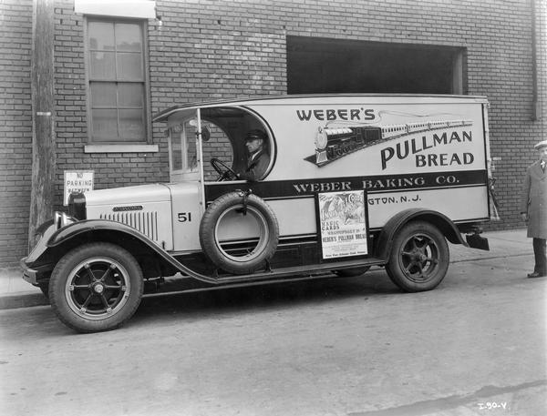 International delivery truck for the Weber Baking Company featuring an illustration of a railroad train and the words "Weber's Pullman Bread." A man is sitting in the driver's seat, and a spare tire is attached to the door. Another man is standing behind the truck on the right. A framed sign attached to the side body of the truck reads: "Invisible color magic cards wrapped daily in Weber's Pullman Bread. Sliced or Unsliced, Pullman Bran-Soderholm Swedish Rye, Sliced Mitynice and Vega-Wheat Bread. Free Fun * Albums * Cash Prizes."