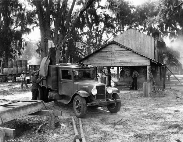 Workers unloading supplies from an International B-4 truck for a still operated by Turpentine and Rosin Factors, Inc. in Jacksonville.