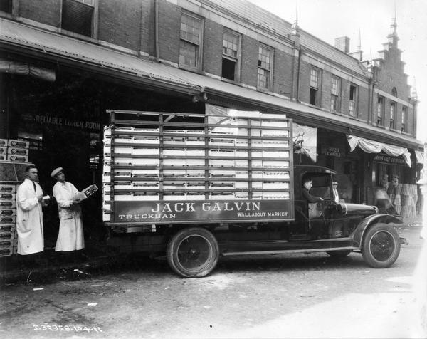 Workers unloading goods from Jack Galvin's International delivery truck outside the Reliable Lunch Room. According to the side of the truck, Galvin was based in the Wallabout Market in Brooklyn.