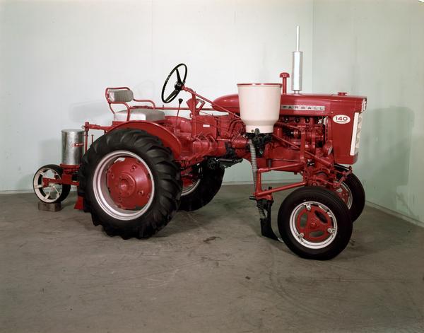 Color engineering photograph of a McCormick Farmall 140 tractor with attached planter.