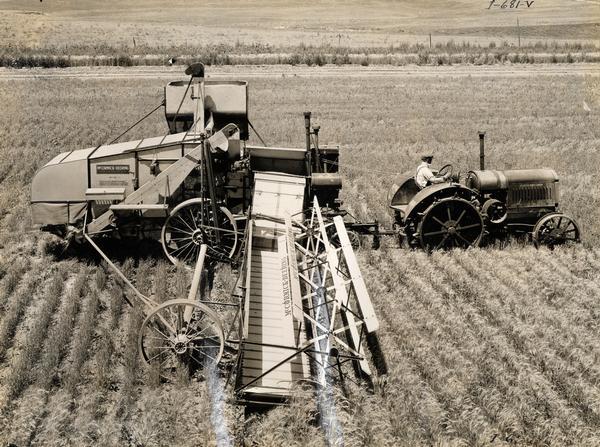 Elevated view of a farmer harvesting grain with a McCormick-Deering tractor and No. 41 16-foot harvester-thresher (combine). The No. 41 featured a 28-inch cylinder and 42-inch separator and was equipped with recleaner and 45-bushel grain tank. At the time of this photograph, which was taken in 1932, only four of these machines (one export) had been built. It was expected that the no. 41 would go into full production as soon as the existing stocks of no. 11 harvester-threshers were depleted, presumably the following year.