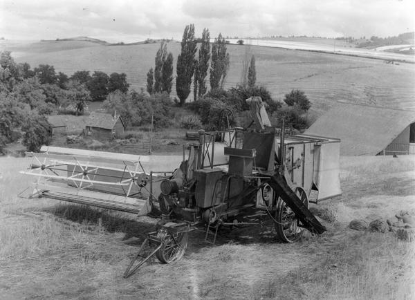 Experimental McCormick-Deering No. 51 hillside harvester-thresher (combine). Original caption reads: "This machine had no recleaner but featured a self-leveling cleaning shoe and chaffer unit which has all the elements of a recleaner. The machine had a 14-foot cutting platform (floating type), straw raddles, and bagging platform. Its construction was rather light for the severe conditions encountered in hillside work and a heavier experimental machine of similar type is to be tried out this coming season (1933)."