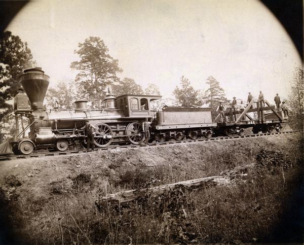 Crew from the Augusta and Knoxville railroad posing with a steam engine.