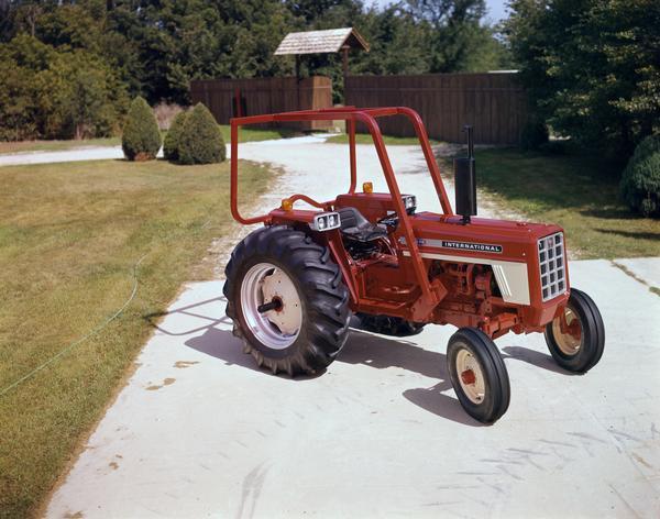 International 574 tractor with attached rollbar parked on a driveway.