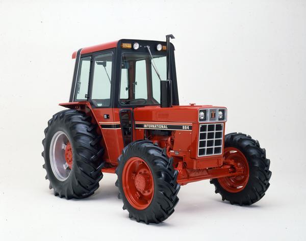 Color photograph of an International 884 4WD tractor with enclosed cab in a studio.