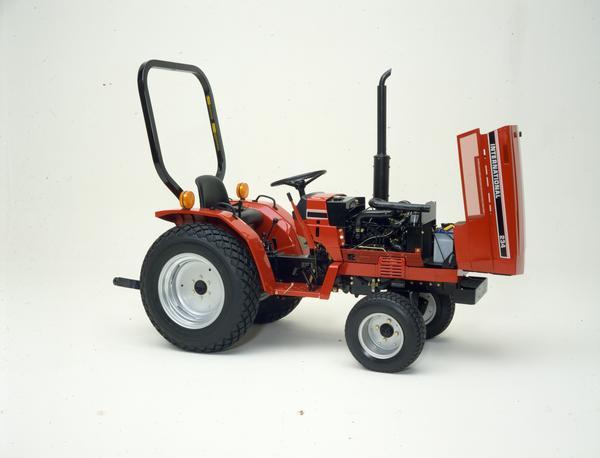 Color photograph of an International 234 tractor in a studio with engine exposed.