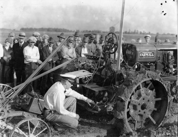Operator J.J. Lynch inspects the wiring on a radio-controlled McCormick-Deering Farmall F-30 tractor at a fair.