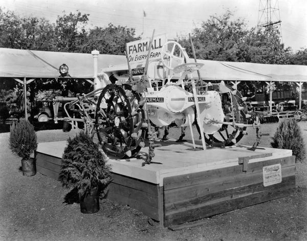 White Farmall Regular tractor with attached cultivator on display at a state fair.
