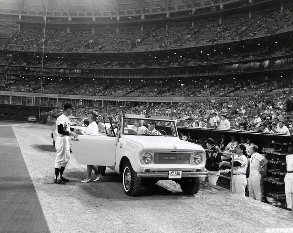 Original caption reads: "A bevy of International Scouts recently helped the Houston Sports Association introduce the families of Astros baseball players to the team's fans. The occasion was 'Meet the Astros Families' night at the Astrodome. The Scout convertible Sportops provided sporty transportation for the wives and children of players in from center field to the Astros' dugout and the ballplayers. After each family group was introduced by both the public address system and the $2 million Astrodome scoreboard, gifts were presented."