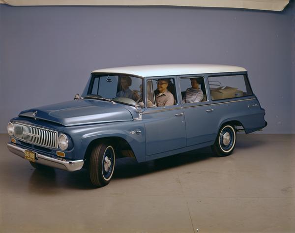 Color advertising photograph of a family in a 1962 International Travelall 1000 pickup in a studio.