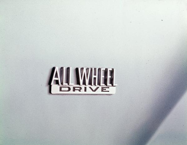 Color studio photograph of the "All Wheel Drive" emblem on the front quarter panel of a 1970 International Scout pickup.