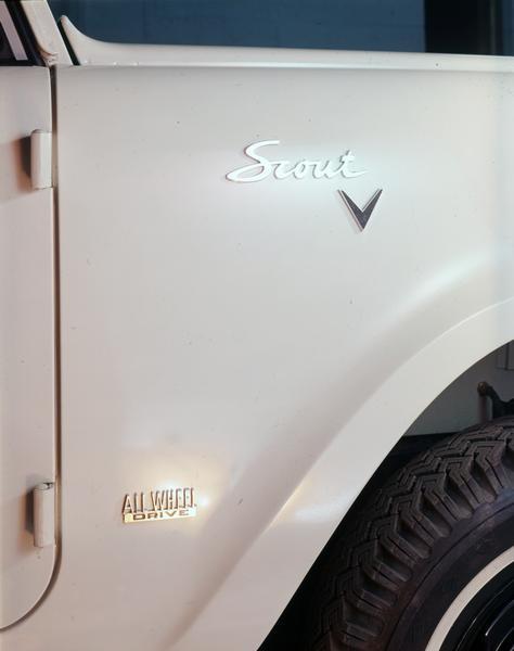 Color photograph close-up of emblems on the front right quarter panel of an International Scout pickup truck.