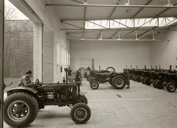 Mechanics working with Deering tractors at a service station in Breslau, Germany.  Original caption reads: "International Harvester Company m.b.H., Breslau 13, Strasse der SA 26. Service station."