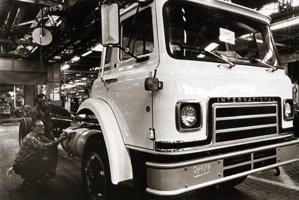Men working on an International Cargostar S-series low-front-entry medium truck on a factory floor at International Harvester's Chatham Works in Ontario, Canada.