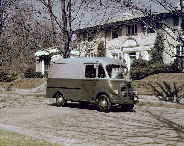 Color photograph of an International Metro Trans delivery truck for Thalimers' Department Store(?) parked outside a house.