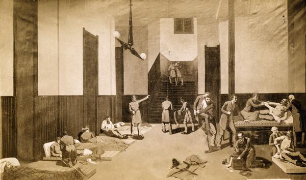 A photograph of a painting depicting the wounded being treated at Desplaines Street police station after the Haymarket Square riot. The riot started as a rally protesting the killing by police officers of two union member McCormick reaper factory workers during a confrontation between the union workers and their replacements the previous day. Later in the evening, police marched into the square and ordered the crowed to disperse. A riot erupted after someone threw a dynamite bomb that exploded, killing and wounding many police and civilians.