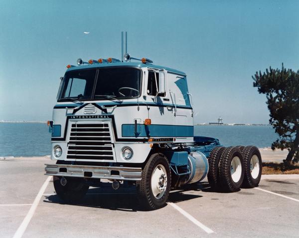 Color advertising photograph of an International Transtar CO-4070 semi-truck parked along a waterfront.