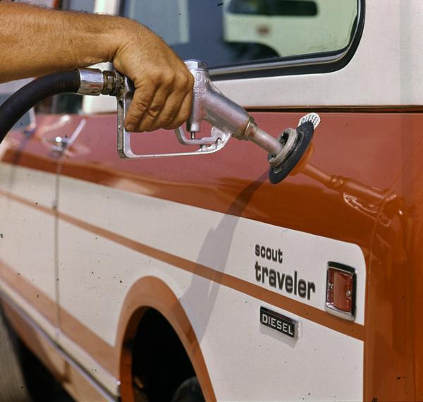 Color photograph of someone pumping diesel fuel into the tank of a International Scout Traveler truck.