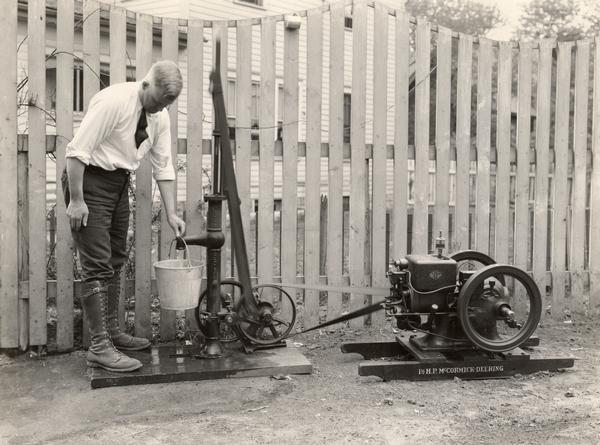 Man pumping water from a well with a McCormick-Deering 1 1/2 HP engine.
