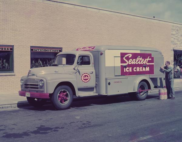 Deliveryman unloading Sealtest ice cream from an International L-162 truck to a drugstore.