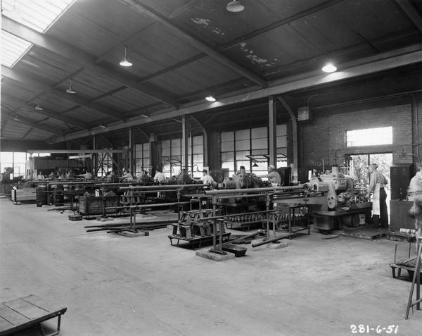 Factory workers on the floor of the Frank G. Hough Company factory (works). The company manufactured construction and industrial equipment. The company was eventually purchased by the International Harvester Company.