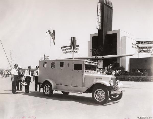 Armed officers and an armored truck owned by the Brinks Express Company outside the Italia building at the Chicago World's Fair "A Century of Progress" exhibition.