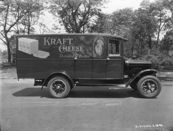 International delivery truck with an advertisement for Kraft Cheese, "Decidedly Better," on the side.