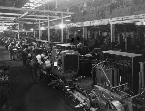 Workers assembling tractors at International Harvester's Milwaukee Works plant. The first tractor in line seems to be a WD-40, while the others are perhaps W-30's.