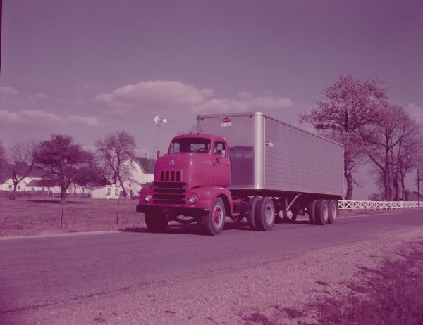 Color photograph of an International R-195 truck with "Truck-Tilt Cab" and closed top van body.