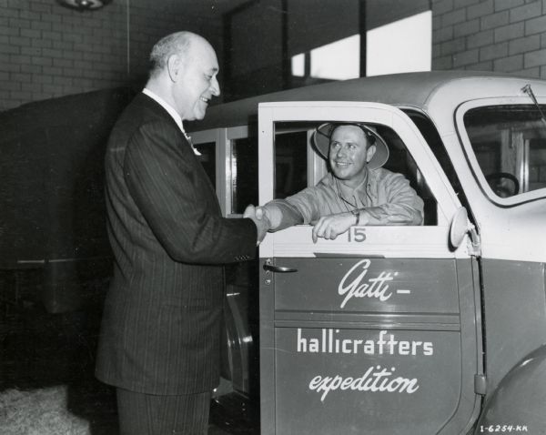 Original caption reads: "Clyde King, Vice President of International Harvester Export Company, bids his son, second officer of the Gatti Hallicrafters Expedition, bon voyage on his impending journey to the "Mountains of the Moon" in British East Africa." The expedition was led by Commander Attilio Gatti and sponsored by International Harvester. Clyde King's son, Weldon King, was the expedition's photographer.