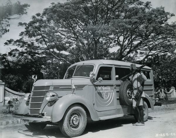 An African man loads an International truck. The truck was produced by International Harvester for Commander Attilio Gatti's tenth African expedition.