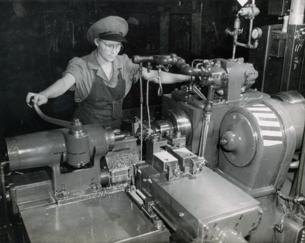 Female worker using a stub lathe to turn, face, groove and "chamfer" chain-tightener sprockets at International Harvester's East Moline Works. The sprockets were used on combines. The East Moline factory was constructed in 1933 and was located at 1100 3rd Street.