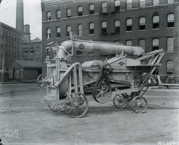 Experimental McCormick "improved 8-roll thresher/shredder" in a factory yard, most likely at International Harvester's McCormick Works.