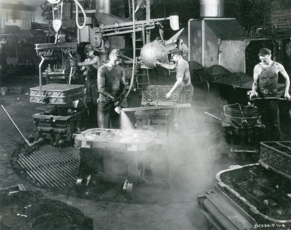Foundry workers forming molds on a turn-table or "merry-go-round" at International Harvester's Milwaukee Works.  The factory was owned by the Milwaukee Harvester Company before 1902.