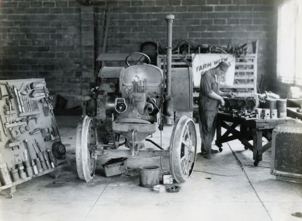 Mechanic working on a tractor in the service station at T.A. Rhudy and Son, an International Harvester farm equipment and truck dealership.