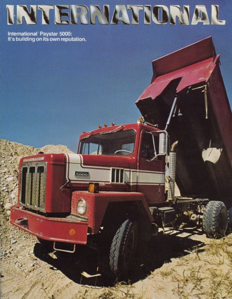 Front cover of an advertising brochure for International Paystar 5000 construction trucks. Features a color photograph of a Paystar 5000 dump truck in a quarry with the motto: "it's building its own reputation."