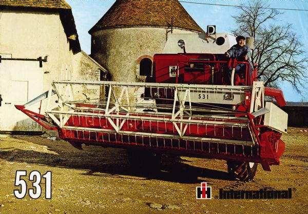 Front cover of a French brochure advertising the International 531 Combine (harvester-thresher). The color photograph shows a man wearing a beret, blue jacket, and blue overalls, at the steering wheel of an International 531. In the background are two connected agricultural buildings, one with a turret.