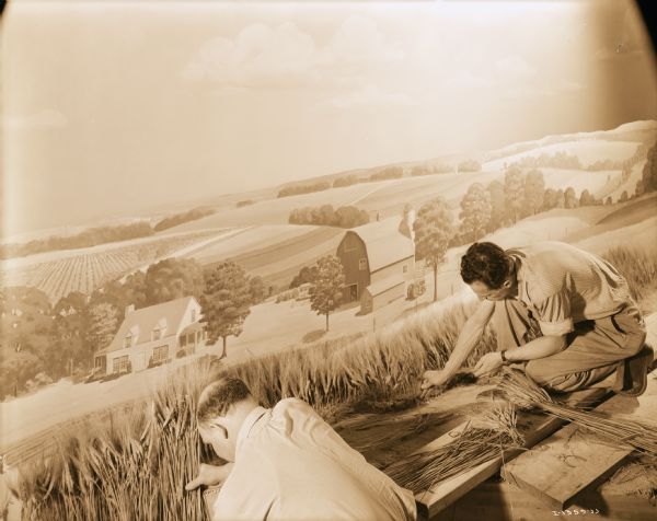 Two men are working on a farm scene for the Harvester Farm exhibit at the Museum of Science and Industry.