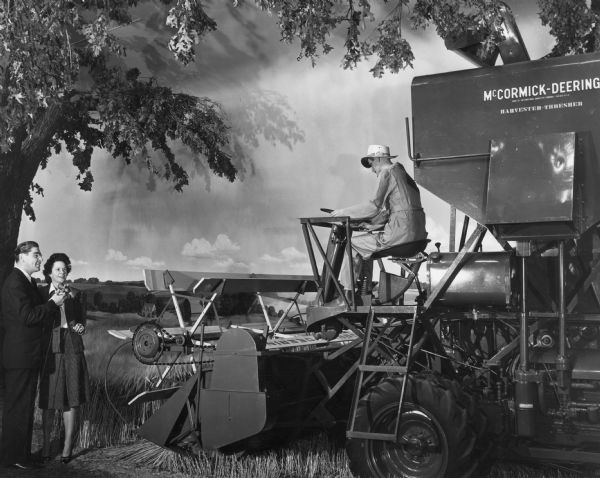 Roen and Elizabeth Hart examining a combine (harvester-thresher) at the Harvester Farm exhibit at the Museum of Science and Industry. A mannequin is sitting on the combine.