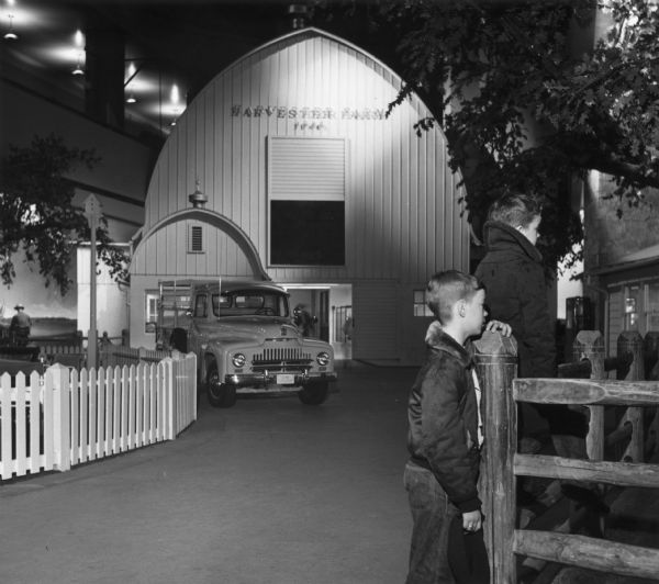 Children visiting the Harvester Farm exhibit at the Museum of Science and Industry. A barn and an International truck are in the background.