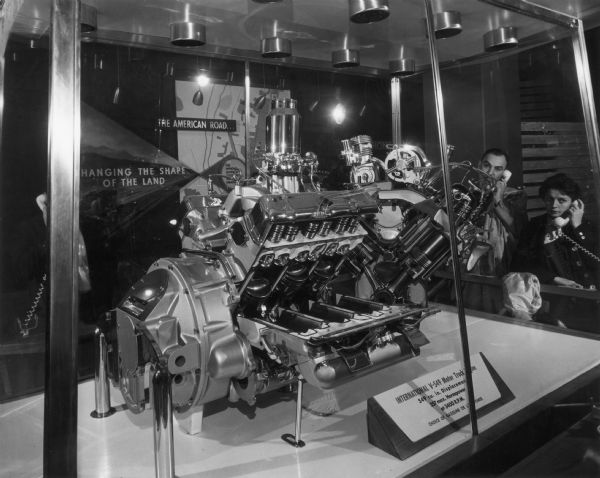 Visitors examining an International V-549 Motor Truck engine on display in International Harvester's exhibit at the Museum of Science and Industry.