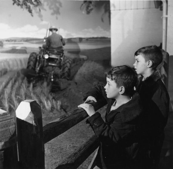Two children at the Harvester Farm exhibit in the Museum of Science and Industry in Chicago. A tractor is in the background.