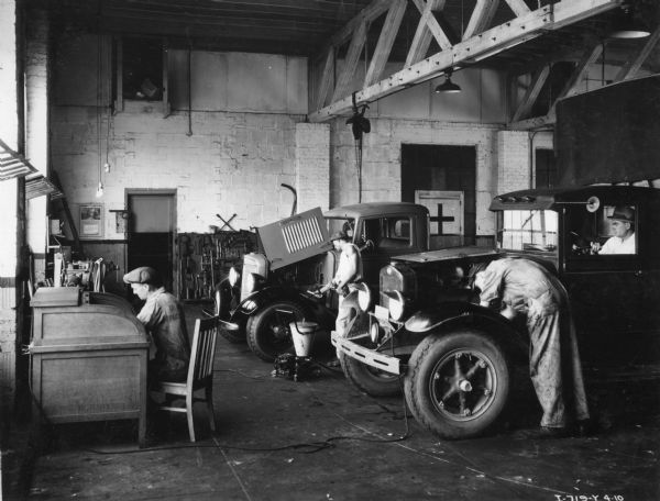 Mechanics working on trucks at the Orange Belt Truck and Tractor Company, an International truck and agricultural equipment dealership.