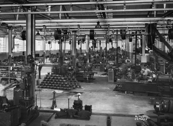 Factory workers operating machinery at International Harvester's Neuss Works in Germany.