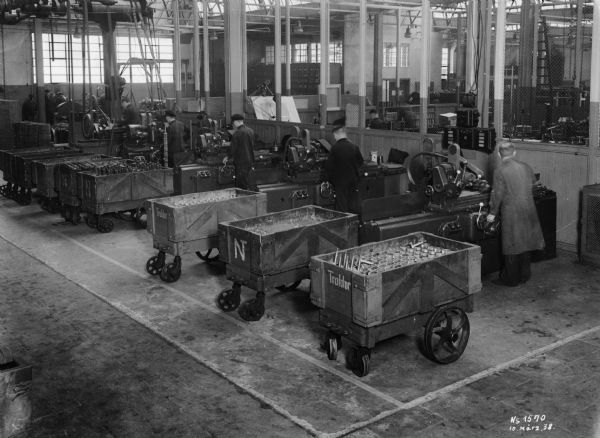 Men work on tractor parts at International Harvester's Neuss Works (factory) in Germany.