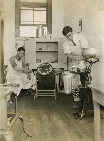 Max Ballard at the separator and Harvie Connell churning in the dairy department of the Pickens County High School.